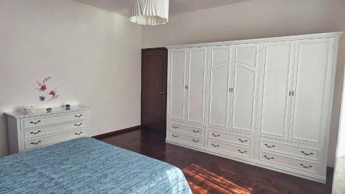 a bedroom with white cabinets and a bed and a dresser at Casa Kendra in Montegrotto Terme