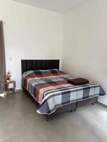a bedroom with a bed in a white room at Chalé portal da serra in Serra do Cipo