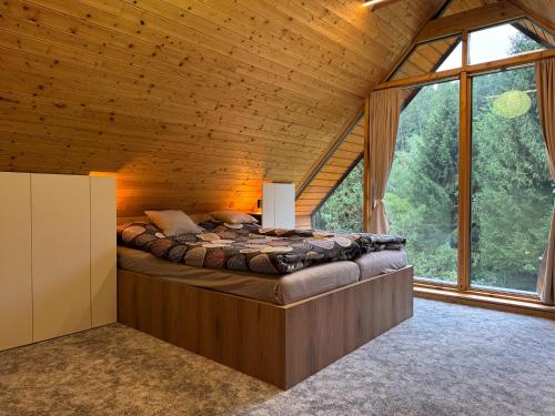 a bedroom with a bed in a room with windows at Chata Pod Dubem Kameňák in Moravany