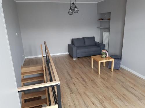 a living room with a blue couch and a table at MazuryTime in Mrągowo
