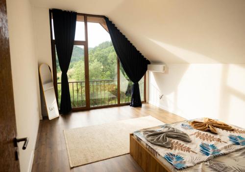 a bedroom with a bed and a large window at Villa Loni in Pozharan