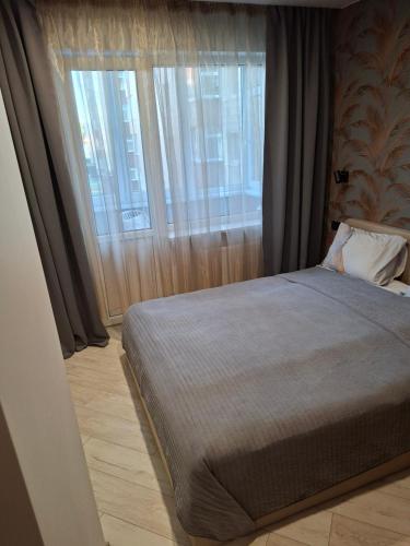 a bedroom with a bed and a large window at Atokvėpis sielai in Šilutė