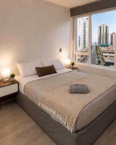 a bedroom with a large bed with a large window at Nómade Summer Home in Iquique
