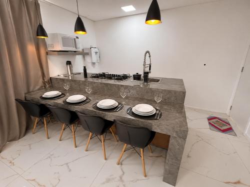 a kitchen with a large counter with chairs and a sink at Aconchego de Lugar - Eri & Douglas - 4 in Belo Horizonte