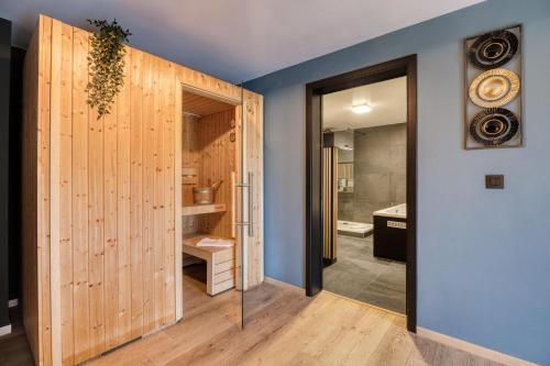 a bathroom with a pivot door and a walk in shower at Hotel & Restaurant Maison Pal'Ange in Durbuy