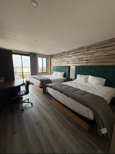 a hotel room with two beds and a desk and a desk at Skylux Hotel - Long Island City in Queens