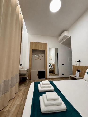 ein Schlafzimmer mit einem Bett mit zwei gefalteten Handtüchern darauf in der Unterkunft CHD Rooms in Ancona