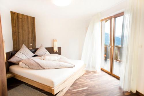 een slaapkamer met een bed en een groot raam bij Prünsterhof Schenna in Schenna