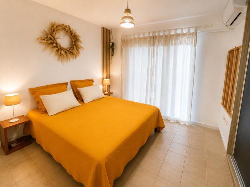 a bedroom with a yellow bed and a window at Between Caribean Seas in Cul de Sac