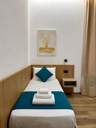 ein Schlafzimmer mit einem Bett mit blau-weißer Bettwäsche in der Unterkunft CHD Rooms in Ancona