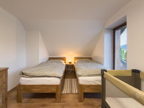 two twin beds in a room with a window at Chata na Lániku in Švošov