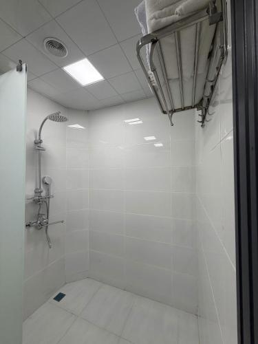 a bathroom with a shower with white tiles at Panorama 7 day's in Hacıselli