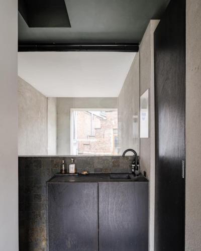 a kitchen with a black counter and a window at Wabi Guesthouse in Ghent