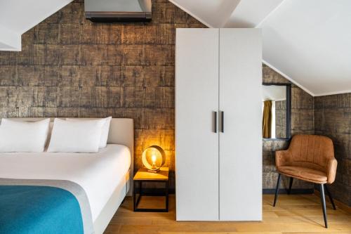 a bedroom with a bed and a chair at Hotel & Restaurant Maison Pal'Ange in Durbuy