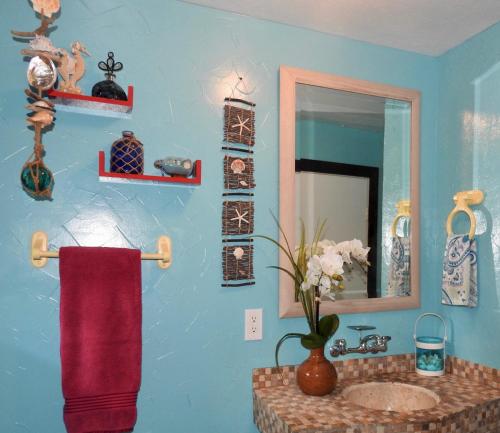 a bathroom with a sink and a mirror at Kalani Hawaii Private Lodging in Pupukea