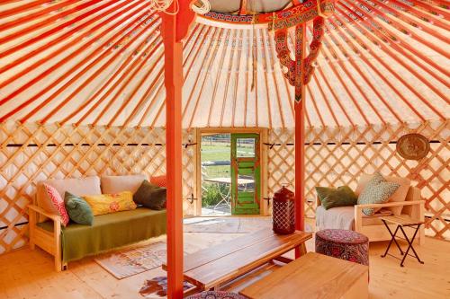 a yurt with a couch and a wooden table at Jurte Falken Nest in Eisenbach