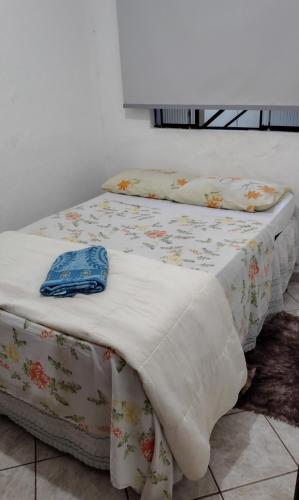a bed with a blanket on top of it at Casinha central Manhuaçu in Manhuaçu