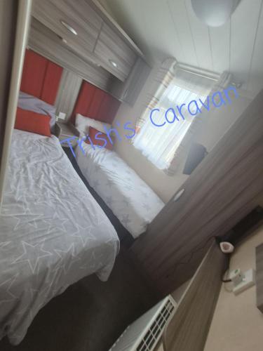 a hotel room with two beds and a window at Trish's Caravan Coop 144 in Kinmel Bay