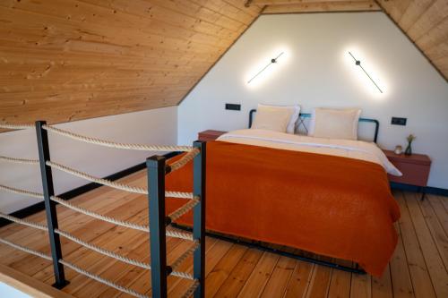 a bedroom in a loft with a bed and a rope at Stodoła Nad Dadajem in Kojtryny