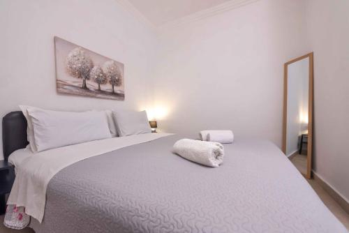 a white bedroom with a large bed with white sheets at Angie's House Volos in Volos