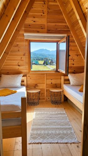 a log cabin with two beds and a window at Guest House Zabljak in Žabljak