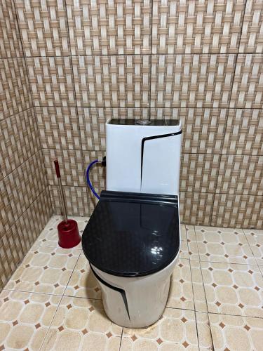 a black and white toilet in a tiled bathroom at Umunota Escape in Bugesera