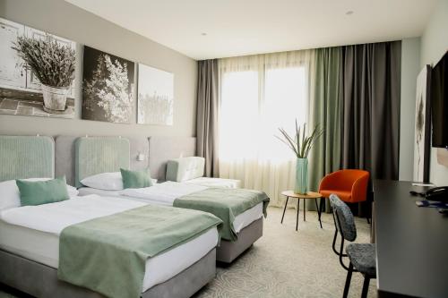 a hotel room with two beds and a desk at Hotel President in Čapljina
