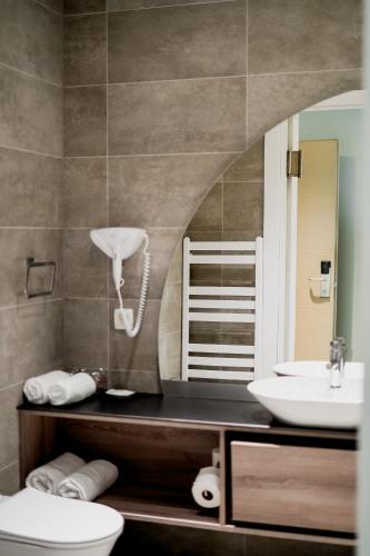 a bathroom with a sink and a toilet and a mirror at Hotel President in Čapljina