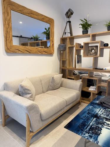 a living room with a couch and a mirror at Villa Mayeux in Giverny