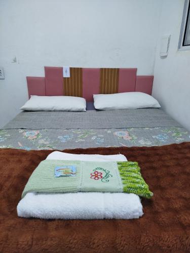two beds in a room with towels on the floor at Minha casa pousada in Botucatu