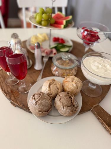 a table with a plate of muffins and glasses of wine at Flishult gård in Vetlanda