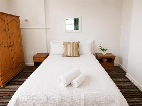 a bedroom with a white bed with towels on it at 52 - room 1 - city views in Swansea