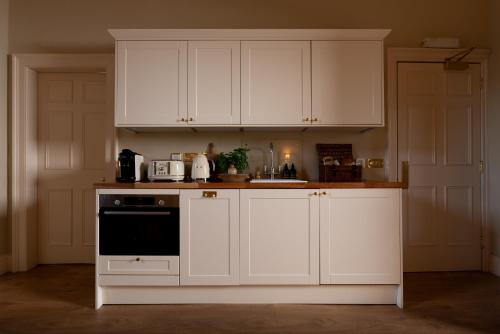a kitchen with white cabinets and a stove top oven at The Townhouse, Leith in Edinburgh