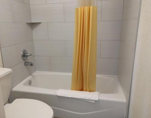 a bathroom with a tub and a shower with a toilet at Red Carpet Inn Airport Fort Lauderdale in Fort Lauderdale