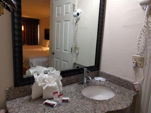a hotel bathroom with a sink and a mirror at Red Carpet Inn Airport Fort Lauderdale in Fort Lauderdale