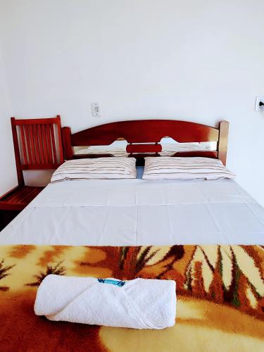 a bed with a pair of towels on the floor at Minha casa pousada in Botucatu