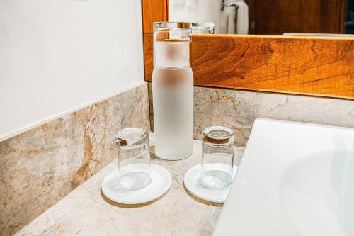 two glasses and a bottle of milk on a counter at Hotel Cucuve in Puerto Ayora