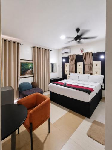 a bedroom with a bed and a couch and a chair at Smarthome Hotel in Benin City