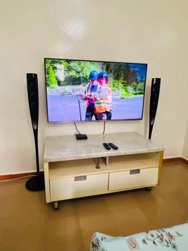 a television with two men playing a song on it at Charming apartment in M'bour + 100 m² + pool in Mbour