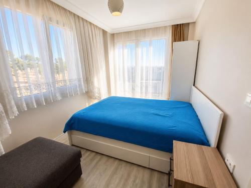 a bedroom with a blue bed and a window at Ada Hill Ayvalık in Ayvalık