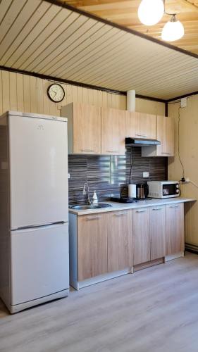 a kitchen with a white refrigerator and wooden cabinets at Оксана та Назар in Mykulychyn