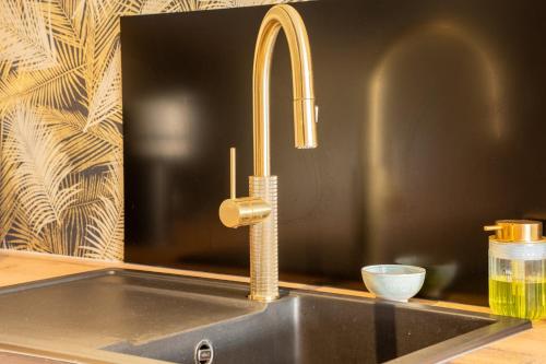a kitchen sink with a gold kitchen faucet at L'Avant-Première Chic 40m2 with Parking in Évreux