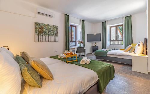 a hotel room with two beds and a tv at Lotus Resort B&B in Pula