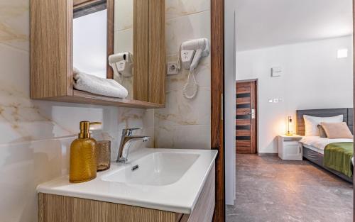 a bathroom with a sink and a mirror and a bed at Lotus Resort B&B in Pula