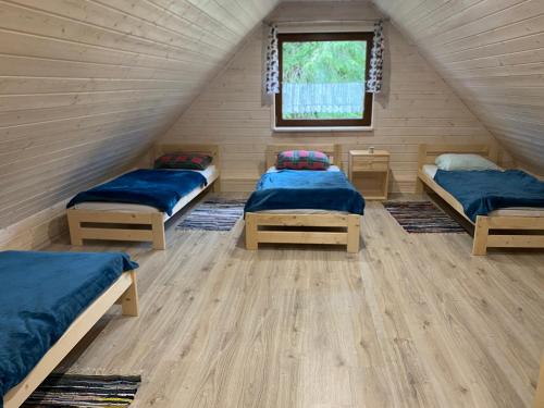 a room with three beds and a window at Leśny Zakątek in Glinka