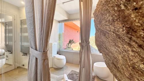 a bathroom with two toilets and a window at Villa Mica in La Maddalena