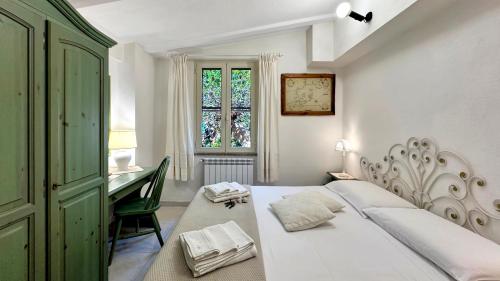 a bedroom with a bed and a desk and a window at Villa Mica in La Maddalena