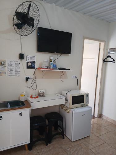 a kitchen with a microwave and a computer on the wall at Edícula 1 em São Pedro in São Pedro