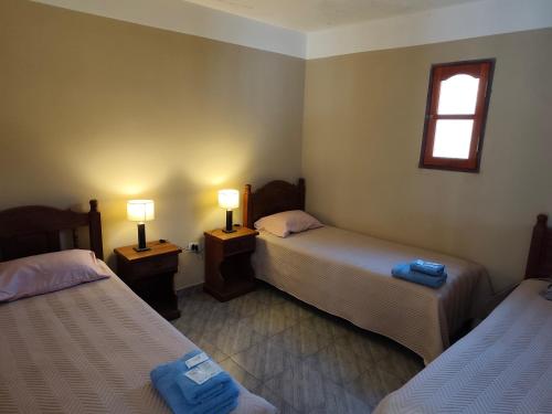 a room with two beds and two lamps in it at El Refugio Departamentos in Iruya