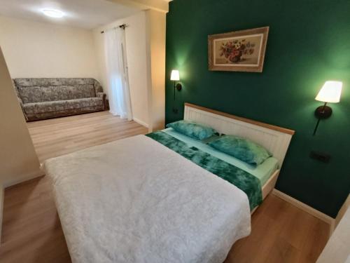 a bedroom with a bed and a green wall at Pergola Garden in Nikšić